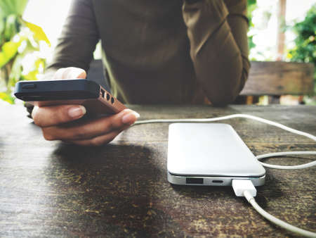 Woman using smart phone with power bankの写真素材