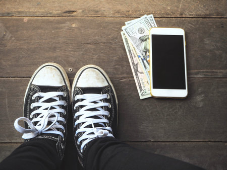 Dollars with smart phone and shoes