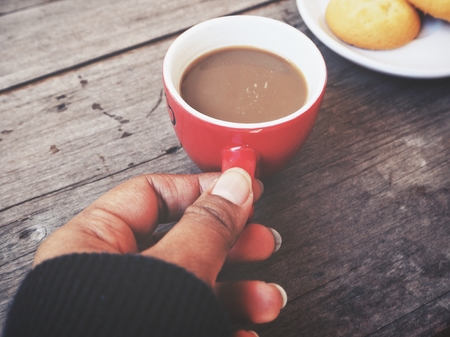Woman drinking coffee with cookie butterの写真素材
