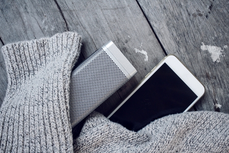 speaker and smart phone with sweater on tableの写真素材