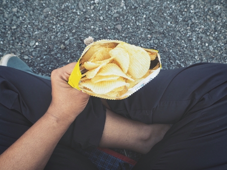 Selfie of hand with potato chipsの写真素材