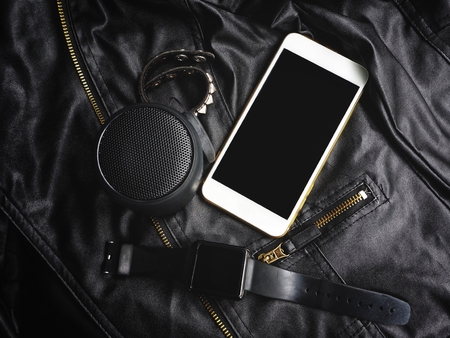 Bluetooth speaker with smart phone and smartwatch on black leatherの写真素材