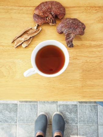 Selfie of ganoderma lucidum tea with shoesの写真素材