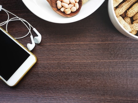 Smart phone with earphone and peanutsの写真素材