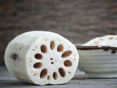 Lotus root on wood backgroundの写真素材
