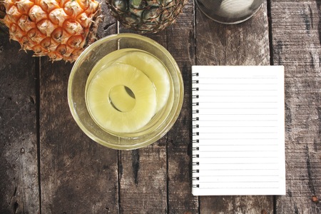 Canned pineapple and blank notepadの写真素材