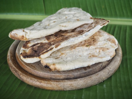 Indian naan bread on banana leavesの写真素材