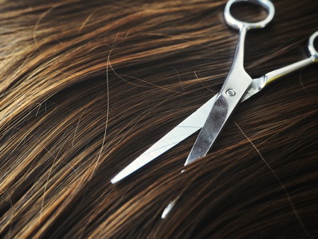 Hair cutting shears and hair with flowersの写真素材
