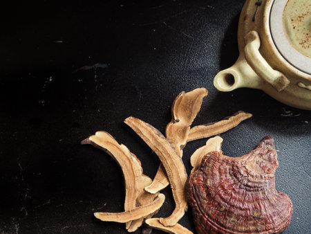 Ganoderma Lucidum - Ling Zhi Mushroom and tea pot on black background