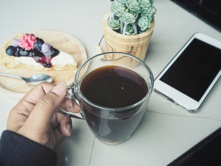 Woman drinking black coffee and blueberry tartの写真素材