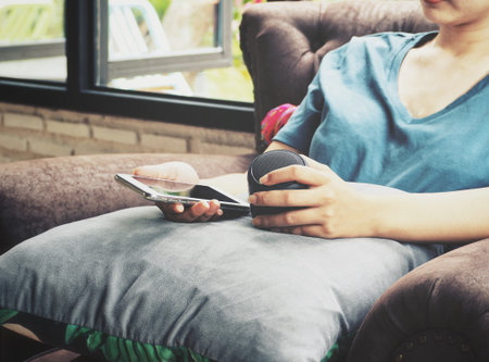 Woman using smart phone and wireless speaker