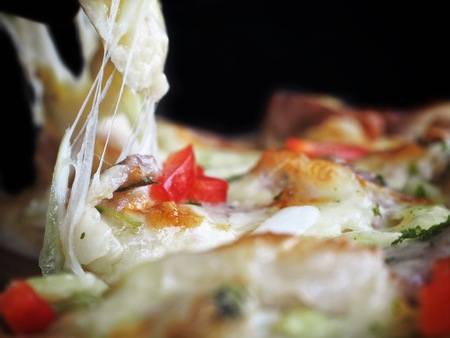 Pizza with cheese Italian food on black backgroundの写真素材