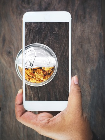 Taking a photo of popcorn caramel with smart phone on handの写真素材