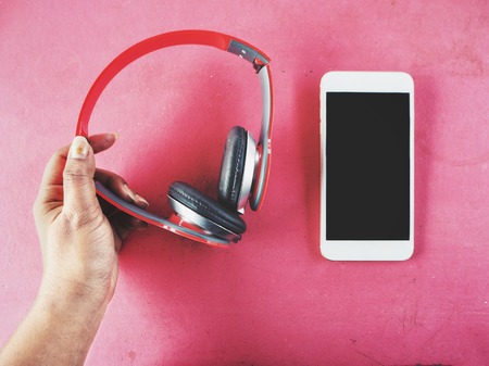 Selfie of headphones with smartphone and handの写真素材
