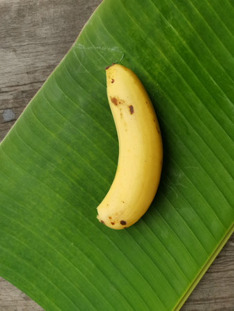 Banana sliced and leaves on wood backgroundの写真素材