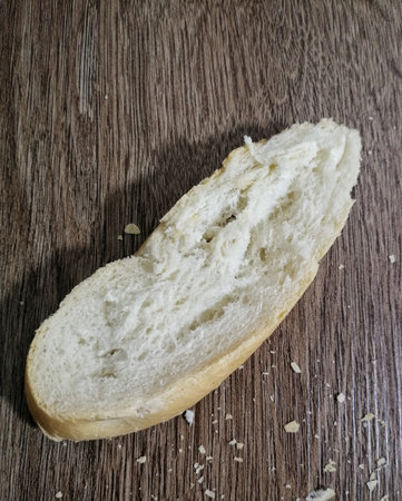Slice bread with shadow on dark wood background
