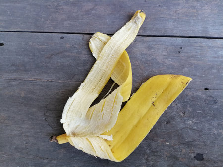 Peel banana on brown wood backgroundの写真素材