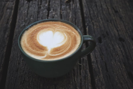 Latte art coffee cup on wooden table