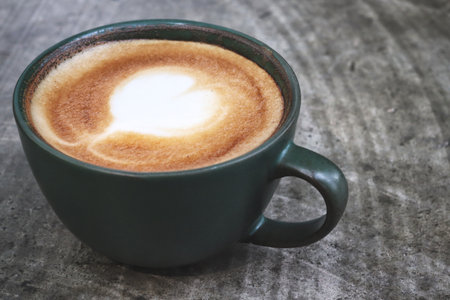 Latte art coffee cup on wooden tableの写真素材