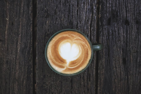 Latte art coffee cup on wooden tableの写真素材