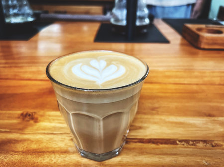 Latte art on brown wooden tableの写真素材