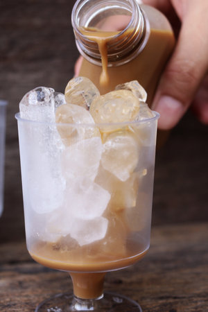Pouring coffee with ice on glass