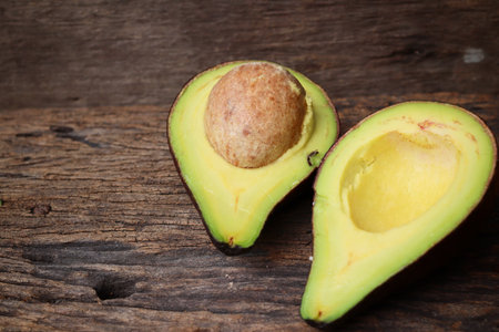 Fresh avocado halves on wooden backgroundの写真素材