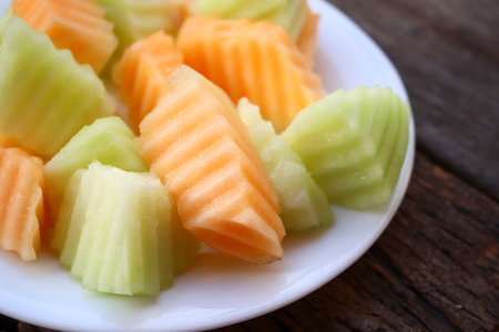 Orange and green melon on wood background