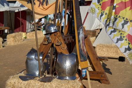 some old armor and spears in bales of straw to lean on