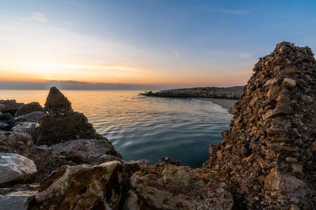 stone breakwater jutting into the sea at dawn timeの写真素材