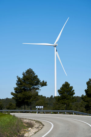 A road near ecological windmills to generate electricity in a natural environmentの写真素材