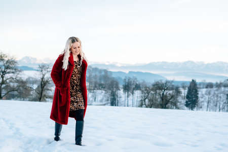 Woman in snow winter landscape warm jacket sexy black bootsの写真素材