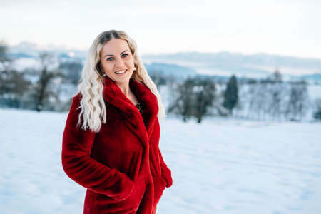 Woman in snow winter landscape warm jacket sexy black bootsの写真素材