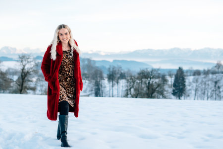 Woman in snow winter landscape warm jacket sexy black bootsの写真素材