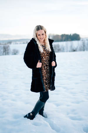 Woman in snow winter landscape warm jacket sexy black bootsの写真素材