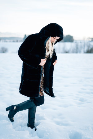Woman in snow winter landscape warm jacket sexy black bootsの写真素材