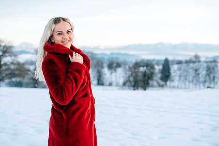 Woman in snow winter landscape warm jacket sexy black bootsの写真素材