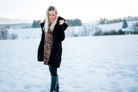 Woman in snow winter landscape warm jacket sexy black bootsの写真素材