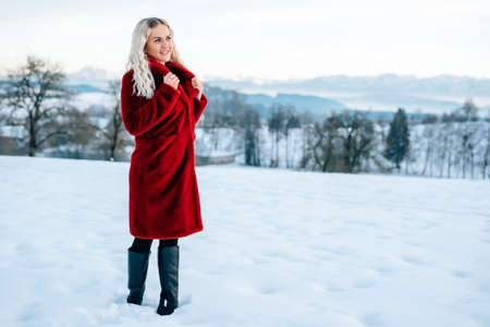 Woman in snow winter landscape warm jacket sexy black bootsの写真素材