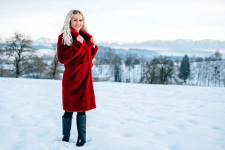 Woman in snow winter landscape warm jacket sexy black bootsの写真素材