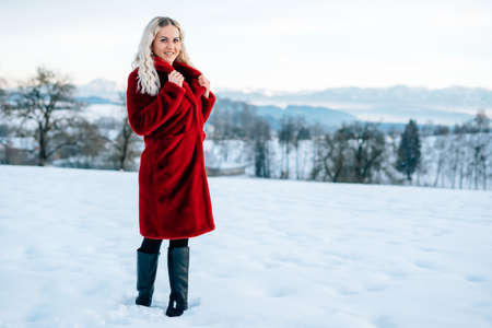 Woman in snow winter landscape warm jacket sexy black bootsの写真素材