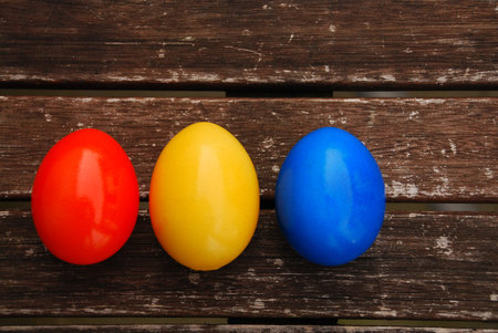 Easter eggs on wooden table Blue, Orange, Yellow