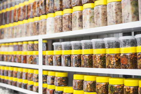 Glass jars with nuts and honey on counter in a marketの写真素材