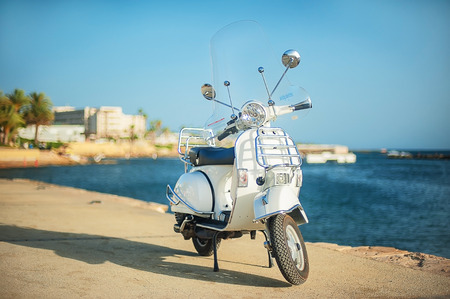 White retro scooter on the beach. Touristic embankmentの写真素材