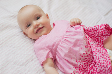 Cute baby girl in pink dress on white backgroun.