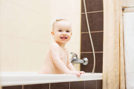Happy cute smiling, baby girl in bathroomの写真素材