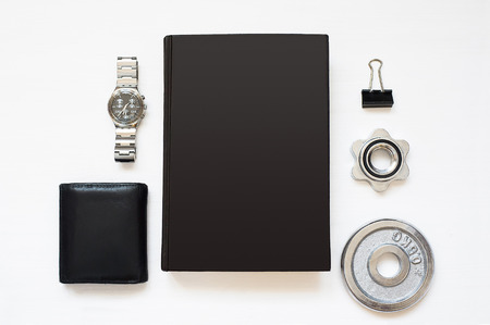 Blank black notebook isolated on white textured wood background with man's things. Flat Lay book. Top View. Copy space.の写真素材
