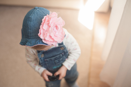 Baby girl in summer hat. Panama with a big pink flower. Without face.の写真素材