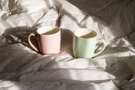 Two mugs of hot chocolate with marshmallows on the bed. Good morning, worldの写真素材