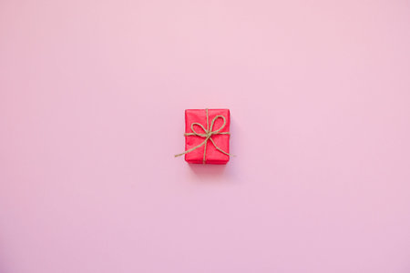 Red gift box on pink background. February 14 card, Valentine's day. 8 March, International Happy...